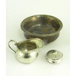 A SOUTH EAST ASIAN SILVER AND WOOD TEA BOWL, A SMALL SILVER CREAM JUG AND A JAR COVER, 2OZS