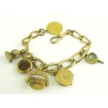 A GOLD CHARM BRACELET, THE CHARMS INCLUDING A HALF SOVEREIGN 1913, 50G