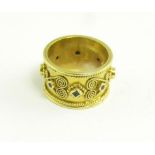 AN ETRUSCAN STYLE GEM SET GOLD BAND RING WITH WIREWORK DECORATION, MARKED 750, 10.7G
