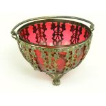 A VICTORIAN EPNS OPENWORK SUGAR BASKET WITH SWING HANDLE AND CRANBERRY GLASS LINER