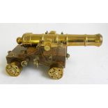 A BRASS MODEL OF A CANNON ON OAK CARRIAGE