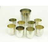 A SET OF EIGHT GERMAN SILVER TOTS BY WILKENS AND A LARGER BEAKER BY THE SAME, 7OZS