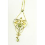 AN ART NOUVEAU PERIDOT AND SEED PEARL SET GOLD OPENWORK PENDANT ON INTEGRAL NECKLET, MARKED 9CT, 4.