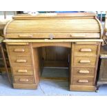 AN OAK DESK, THE TOP ENCLOSED BY A TAMBOUR SHUTTER, EARLY 20TH CENTURY