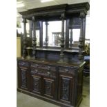 A VICTORIAN CARVED OAK SIDEBOARD WITH MIRROR BACK, THE HANDLES AS A GROTESQUE MASK
