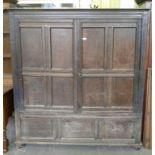 A GEORGE III OAK PRESS CUPBOARD ENCLOSED BY QUADRUPLE PANELLED DOORS