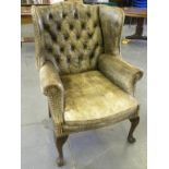 A GEORGE II STYLE WING ARMCHAIR UPHOLSTERED IN CLOSE NAILED FADED GREEN HIDE, WITH CUSHION