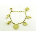 A GOLD CHARM BRACELET, THE CHARMS INCLUDING A GILT SILVER THREEPENCE, 17.3G