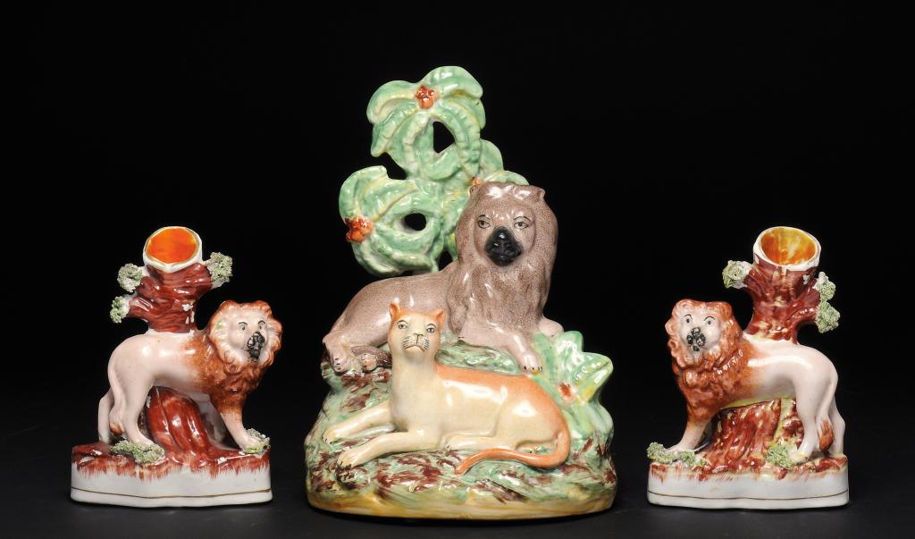 A PAIR OF STAFFORDSHIRE EARTHENWARE LION SPILL HOLDERS AND A GROUP OF A LION AND LIONESS AT LODGE,