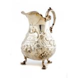 A VICTORIAN SILVER CREAM JUG chased with flowers and rocaille, 14cm h, by Robert Harper & Son,