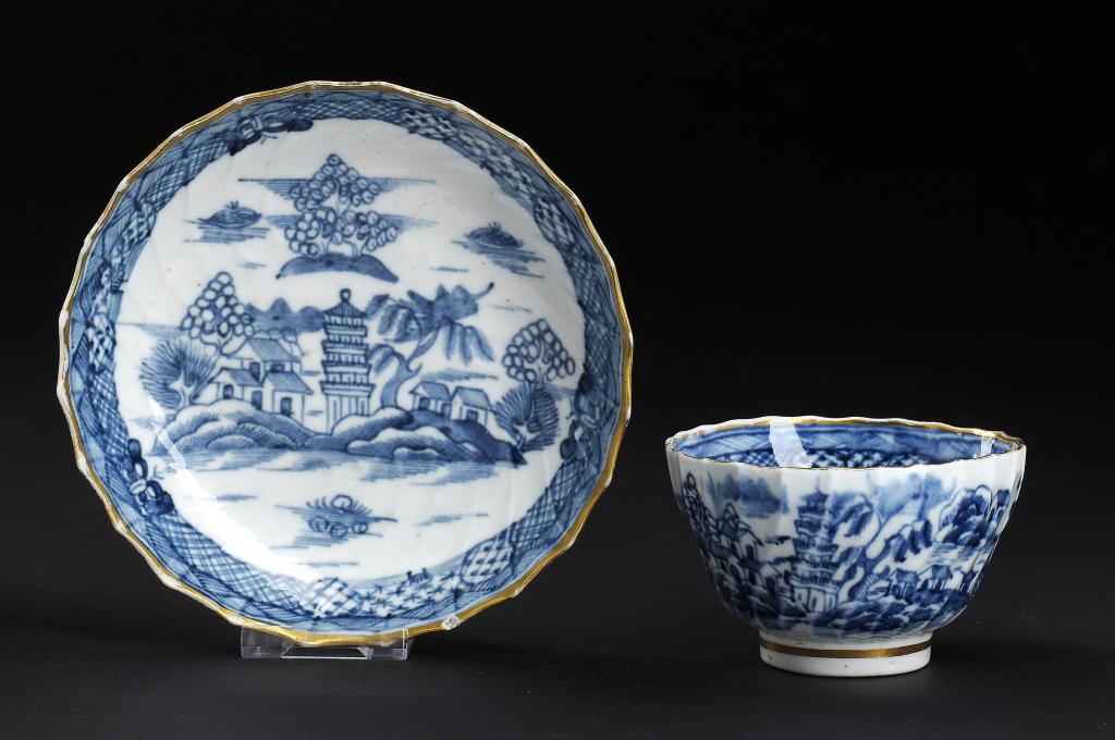 A CAUGHLEY BLUE AND WHITE SHANKED TEA BOWL AND SAUCER, C1790 painted with the Tower pattern,