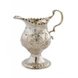 A GEORGE III SILVER REPOUSSÉ OGEE CREAM JUG with a bird on a branch to both sides, 9.5cm h, maker'