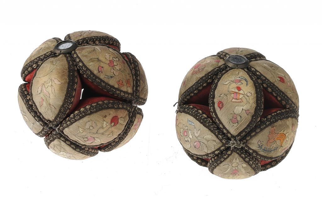 A PAIR OF EMBROIDERED SILK PIN CUSHIONS IN THE FORM OF A BALL, 19TH C composed of 12 navette