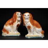 A PAIR OF STAFFORDSHIRE EARTHENWARE MODELS OF SPANIELS ON CUSHIONS LATE 19TH C with glass eyes, 31cm