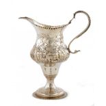 A GEORGE III SILVER REPOUSSÉ OGEE CREAM JUG with a woman milking a cow to one side, a swan to the