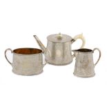 A VICTORIAN SILVER THREE PIECE TEA SERVICE the teapot with integral hinge to the flat lid and