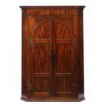 A GEORGE III MAHOGANY CORNER CUPBOARD, C1800 the interior fitted with three drawers and shelves,