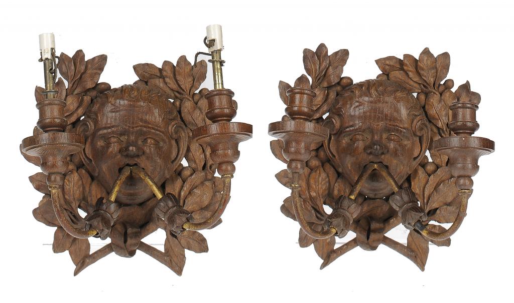 A PAIR OF CARVED OAK MASK WALL LIGHTS, EARLY 20TH C with two metal branches, 27cm h, stamped on iron