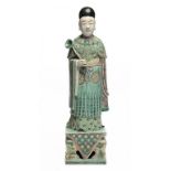 A CHINESE FAMILLE VERTE FIGURE OF AN ATTENDANT, 19TH C the long flowing robe painted overall with