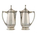 A PAIR OFARTS & CRAFTS SILVER COMMEMORATIVE CAFE AU LAIT POTS BY OMAR RAMSDEN the spire finials with