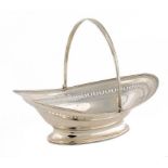 A GEORGE III SILVER CAKE BASKET with reeded swing handle, engraved with armorials, 36cm w, marks