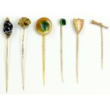 SIX GOLD STICKPINS VARIOUSLY WITH BANDED AGATE, ENGRAVED GOLD SHIELD OR OTHER TERMINAL, 17.4G GROSS