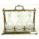 AN EPNS TANTALUS WITH SET OF THREE CUT GLASS DECANTERS AND STOPPERS, EARLY 20TH CENTURY