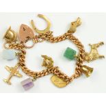 A 9CT GOLD CURB BRACELET, MOUNTED WITH VARIOUS GOLD AND HARDSTONE CHARMS, 9CT GOLD PADLOCK, 29.6G