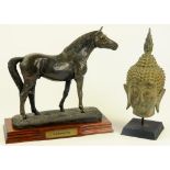 A BRONZED RESIN SCULPTURE OF A STALLION AND A SOUTH EAST ASIAN CAST METAL HEAD OF BUDDHA