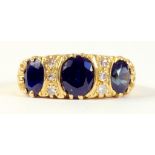 A SAPPHIRE AND DIAMOND RING IN 18CT GOLD, WITH ENGRAVED SHOULDERS, 7.4G