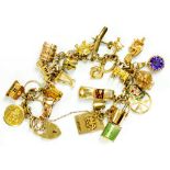 A 9CT GOLD BRACELET, WITH A LARGE AND VARIED COLLECTION OF GOLD CHARMS AND 9CT GOLD PADLOCK, 88.7G