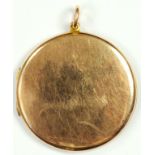 A PLAIN ROUND GOLD AND BASE METAL LOCKET