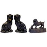 A BASALT TYPE MODEL OF A LION AND A PAIR OF STAFFORDSHIRE BLACK GLAZED EARTHENWARE SPANIELS