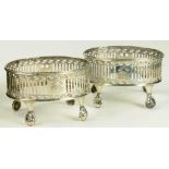 A PAIR OF GEORGE III PIERCED AND BRIGHT CUT SILVER OVAL SALT CELLARS ON FOUR CLAW AND BALL FEET,