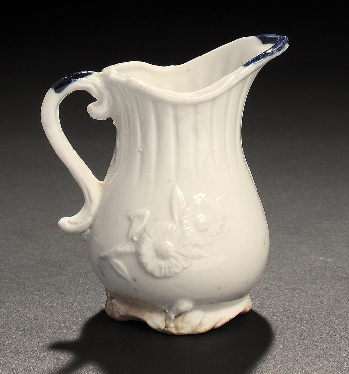 AN INTERESTING UNASCRIBED ENGLISH PORCELAIN BLUE AND WHITE CREAM JUG, C1770-80  moulded to either
