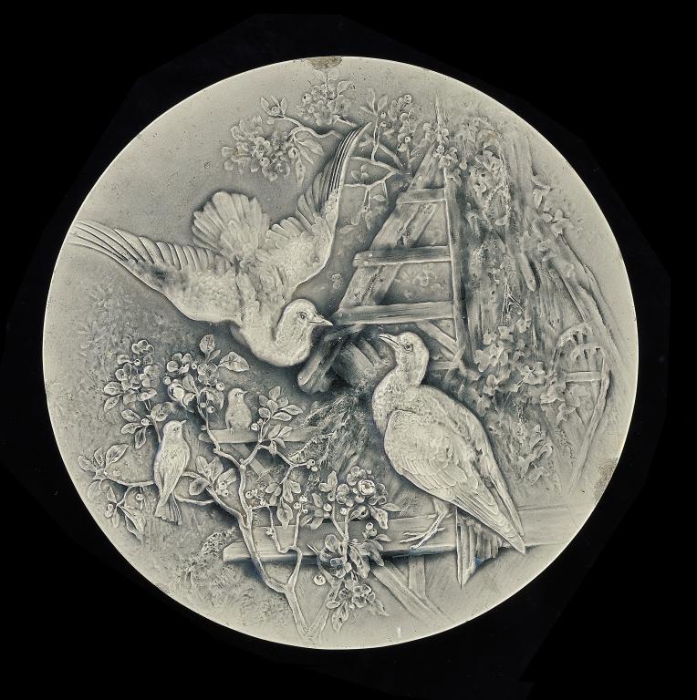 A BURMANTOFTS GREY MAJOLICA PLAQUE, C1890  moulded in relief with a family of birds, 63cm diam,