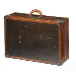 A LOUIS VUITTON SUITCASE, C1930  covered in LV monogrammed brown fabric trimmed in tan hide, linen
