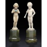 FERDINAND PREISS. TWO IVORY FIGURES OF A BOY WITH HORN AND  A GIRL WITH A CASKET, C1930  on onyx
