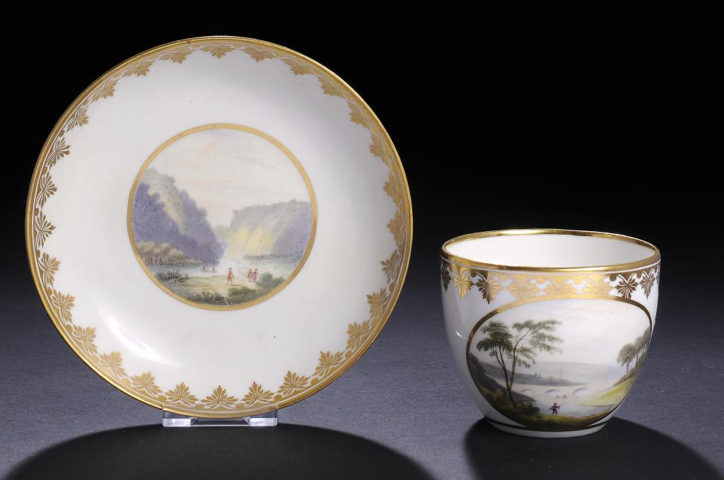 A DERBY TEACUP AND SAUCER, C1790 painted by Zachariah Boreman with landscapes, saucer 13.5cm diam,