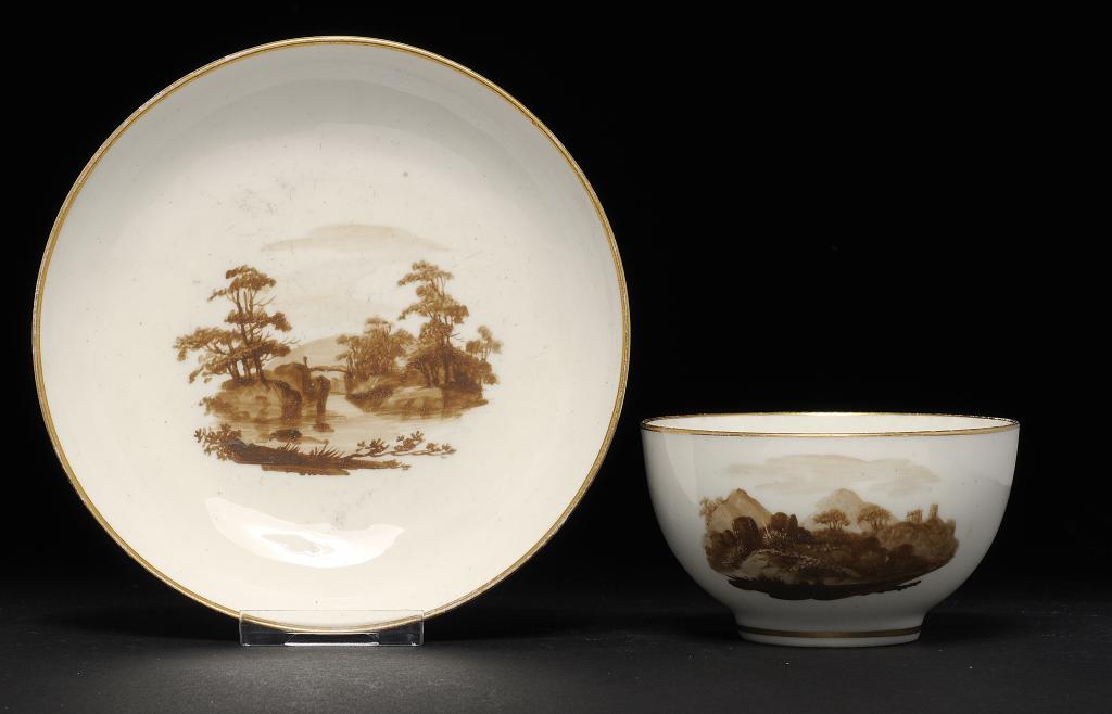 A PINXTON TEA BOWL AND SAUCER, 1796-1813  painted with landscapes, saucer 13.5cm diam  ++Saucer with