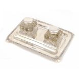 A GEORGE V SILVER INKSTAND with a pair of silver capped glass inkwells, 25cm w, by Walker & Hall,