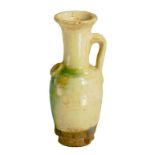 A CHINESE EARTHENWARE WATER DROPPER, TANG DYNASTY  covered in a cream glaze splashed in green and