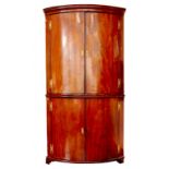 A GEORGE III MAHOGANY BOW FRONTED STANDING CORNER CUPBOARD WITH BRASS H HINGES