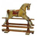 AN EARLY 20TH CENTURY CARVED AND PAINTED WOOD ROCKING HORSE ON PINE STAND