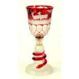 A BOHEMIAN RUBY FLASHED AND WHEEL ENGRAVED GLASS GOBLET THE SLIGHTLY FLARED AND FACETED BOW ENGRAVED