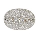 A DIAMOND BROOCH, C1940  the pierced oval plaque with twin central clusters ++An impressive jewel in