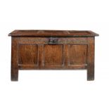 AN OAK CHEST, EARLY 18TH C   with three panel lid and front, lunette carved frieze with iron