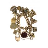 A GOLD CHARM BRACELET  mounted with a collection of gold charms, a half sovereign and a Victorian