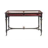 A VICTORIAN EBONISED AND ORMOLU MOUNTED DISPLAY TABLE BY HOWARD & SONS, C1880  on brass castors,