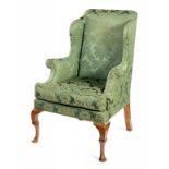 A GEORGE II STYLE WING ARMCHAIR, C1930  on walnut cabriole legs, upholstered in 18th c style green